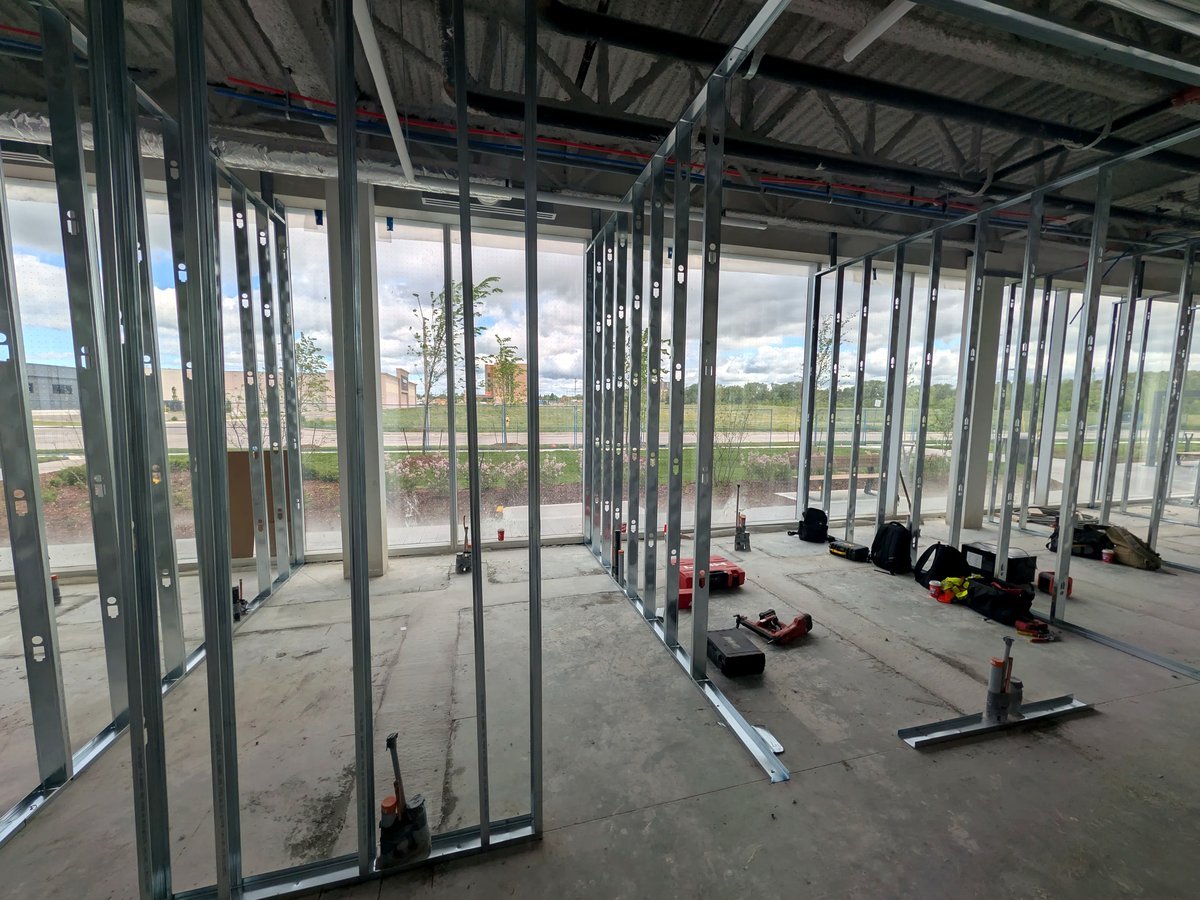 Construction phase of Stouffville Dental Studio’s clinical floor, with steel framing in place and full-height glass exterior walls visible — showing the natural light every treatment room will face